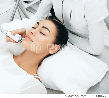 Using the LPG apparatus, the beautician doing a face lift massage. The skin becomes more elastic. Face contour lift 139140677