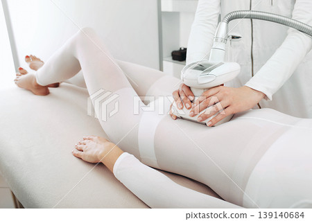 Beautician doing a beautiful figure for a woman, using the LPG apparatus. 139140684