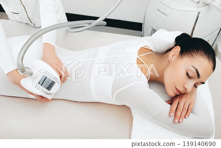 beautiful woman enjoys an LPG massage procedure. After the procedure, she will not have cellulite beautiful woman enjoys an LPG massage procedure. After the procedure, she will not have cellulite 139140690