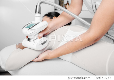 beautician doing lpg massage against cellulite on female body beautician doing lpg massage against cellulite on female body 139140752