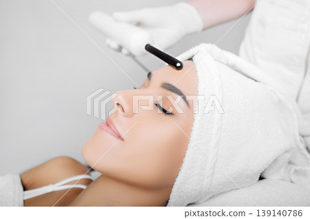 woman getting electric darsonval facial massage procedure at beauty salon. woman getting electric darsonval facial massage procedure at beauty salon. 139140786