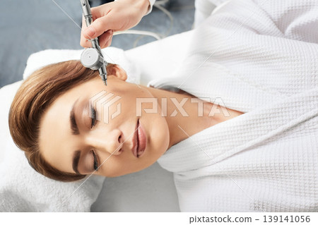 Jet peeling skin renewal procedure. Cropped woman's face with eye close while jet peel procedure 139141056