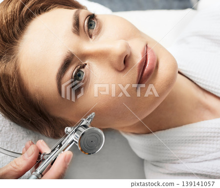 Jet peeling, anti-aging face peel procedure for regenerate skin. Adult woman during jet peeling procedure, close-up Jet peeling, anti-aging face peel procedure for regenerate skin. Adult woman during jet peeling procedure, close-up 139141057