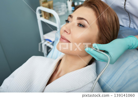 Facial ozone therapy for woman's face rejuvenation at a beauty salon. Oxygen treatment for skin 139141060