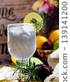 Soft drink glass with lemon and ice, decorated with fresh fruits on a rustic wooden table 139141200