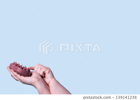 Pink silicone scalp massager in woman hand mockup. Hair brushing and massage. Isolated image for design 139141238