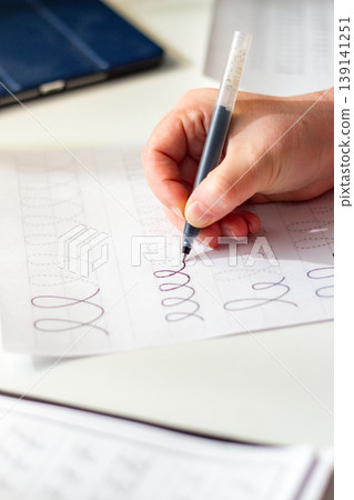 Quiet scene of woman writing with pen. Training accurate handwriting. Therapeutic habit to reduce anxiety and increase clarity. Calmness and digital detox Quiet scene of woman writing with pen. Training accurate handwriting. Therapeutic habit to reduce anxiety and increase clarity. Calmness and digital detox 139141251