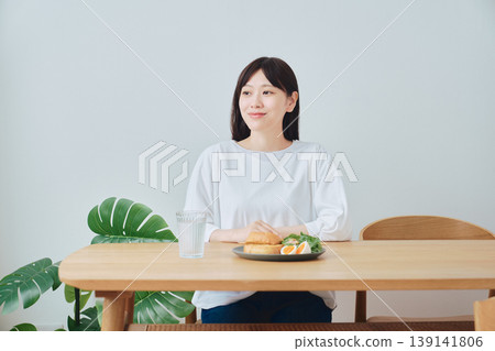A woman enjoying a healthy breakfast; an image of a well-balanced diet. 139141806