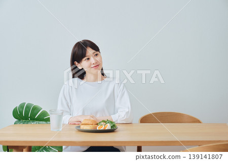 A woman enjoying a healthy breakfast; an image of a well-balanced diet. A woman enjoying a healthy breakfast; an image of a well-balanced diet. 139141807