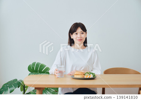 A woman enjoying a healthy breakfast; an image of a well-balanced diet. A woman enjoying a healthy breakfast; an image of a well-balanced diet. 139141810