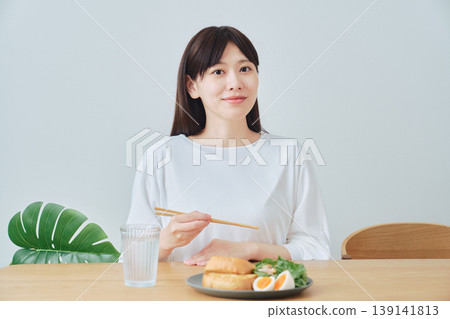 一位女士正在享用健康的早餐;這是均衡飲食的象徵。 一位女士正在享用健康的早餐;這是均衡飲食的象徵。 139141813