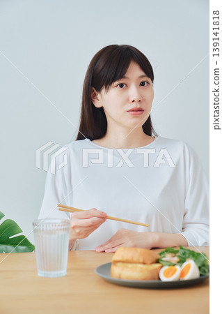 A woman enjoying a healthy breakfast; an image of a well-balanced diet. A woman enjoying a healthy breakfast; an image of a well-balanced diet. 139141818