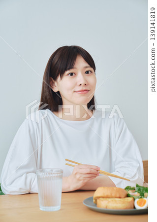 A woman enjoying a healthy breakfast; an image of a well-balanced diet. 139141819