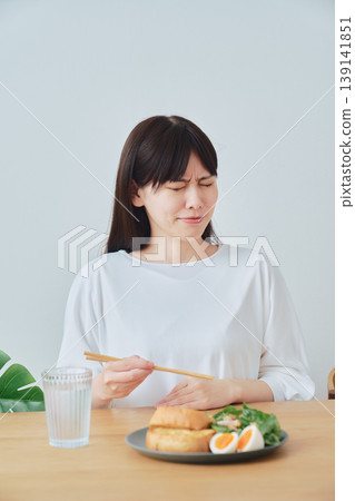 一位女士在早餐時感到不適；食慾不振的畫面。 139141851