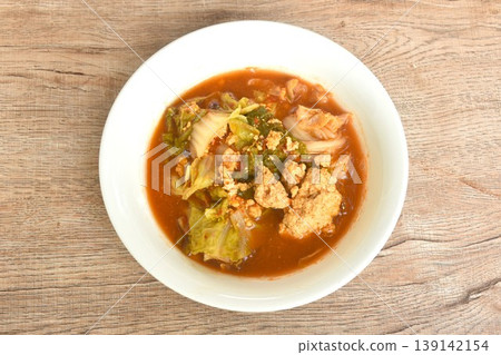 boiled mixed vegetable and fish egg in Thai spicy curry soup on bowl 139142154