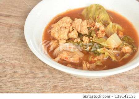 boiled mixed vegetable and fish egg in Thai spicy curry soup on bowl 139142155