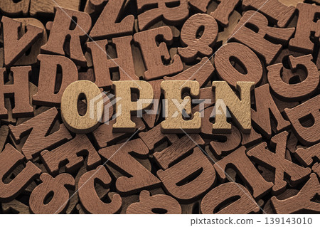 Inscription open on pile of old brown wooden letters. Inscription open on pile of old brown wooden letters. 139143010