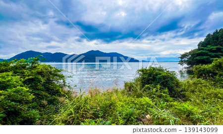 The tranquil surface of Lake Biwa and the mountain range stretching out on the opposite shore. The tranquil surface of Lake Biwa and the mountain range stretching out on the opposite shore. 139143099