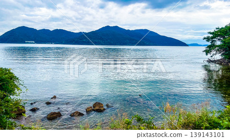 The tranquil surface of Lake Biwa and the mountain range stretching out on the opposite shore. The tranquil surface of Lake Biwa and the mountain range stretching out on the opposite shore. 139143101