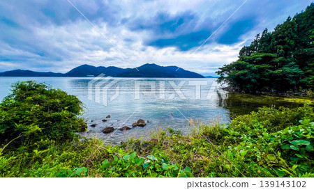 The tranquil surface of Lake Biwa and the mountain range stretching out on the opposite shore. The tranquil surface of Lake Biwa and the mountain range stretching out on the opposite shore. 139143102