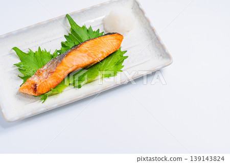 Salt-grilled salmon with grated daikon radish: A classic Japanese dish of grilled fish served on a long white plate. Salt-grilled salmon with grated daikon radish: A classic Japanese dish of grilled fish served on a long white plate. 139143824
