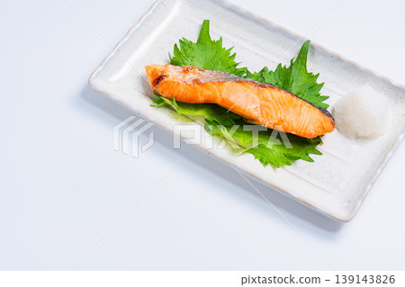 Salt-grilled salmon with grated daikon radish: A classic Japanese dish of grilled fish served on a long white plate. Salt-grilled salmon with grated daikon radish: A classic Japanese dish of grilled fish served on a long white plate. 139143826