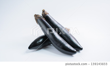 A cutout image of fresh vegetables, featuring long eggplants arranged against a white background. 139143833
