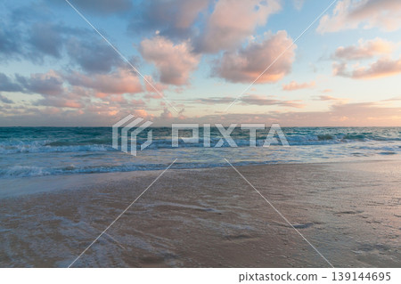 Calm beach at sunset with gentle turquoise waves Calm beach at sunset with gentle turquoise waves 139144695