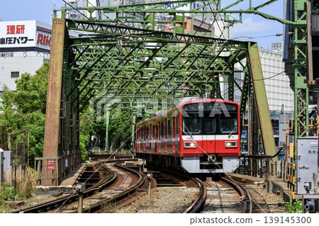 A Keikyu 1500 series local train crossing the Yatsuyama Bridge. A Keikyu 1500 series local train crossing the Yatsuyama Bridge. 139145300
