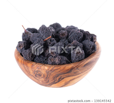 Dried aronia berries isolated on white background. Dry black chokeberry in wooden bowl. Clipping path. Dried aronia berries isolated on white background. Dry black chokeberry in wooden bowl. Clipping path. 139145542