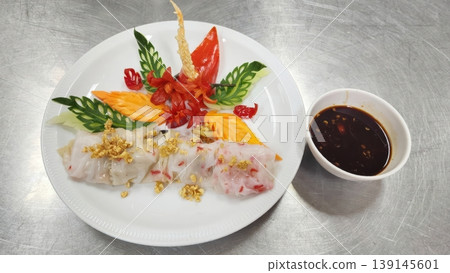 Authentic Thai Steamed Rice Noodle Rolls Garnished with Intricate Vegetable Carving Art Authentic Thai Steamed Rice Noodle Rolls Garnished with Intricate Vegetable Carving Art 139145601