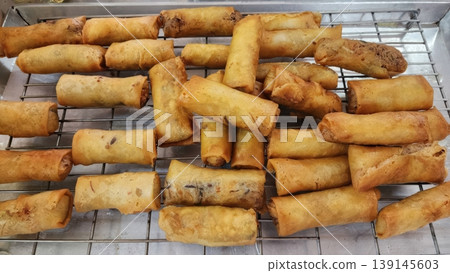 Crispy Golden Brown Fried Spring Rolls on a Wire Cooling Rack in Kitchen Crispy Golden Brown Fried Spring Rolls on a Wire Cooling Rack in Kitchen 139145603
