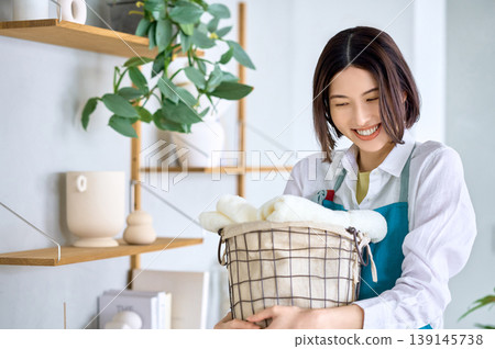 一位面帶微笑、手拿乾淨毛巾的年輕女子：舒適的日常生活。 139145738