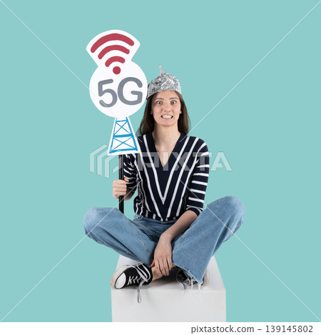 Woman fears 5g radiation wearing tinfoil hat Woman fears 5g radiation wearing tinfoil hat 139145802