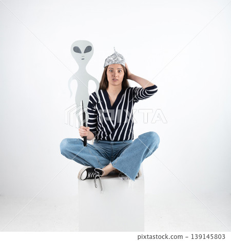 Young woman believing in aliens wearing tin foil hat Young woman believing in aliens wearing tin foil hat 139145803