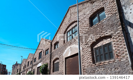 Old Industrial Brick Building Facade Under Blue Sky Old Industrial Brick Building Facade Under Blue Sky 139146417