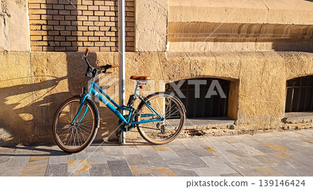Blue Bike Parked by Stone Wall in Golden Afternoon Light Blue Bike Parked by Stone Wall in Golden Afternoon Light 139146424