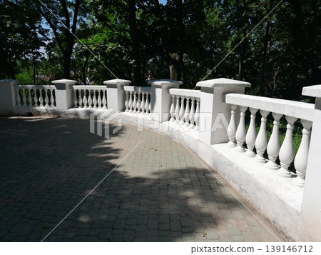 Sunny Park Staircase with White Balustrade and Lush Green Trees in Summer Sunny Park Staircase with White Balustrade and Lush Green Trees in Summer 139146712