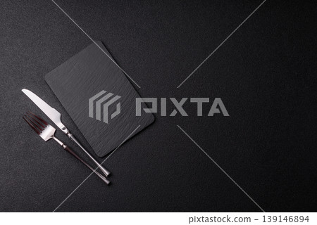 An empty slate cutting board with cutlery on a kitchen counter. Slate cutting board An empty slate cutting board with cutlery on a kitchen counter. Slate cutting board 139146894
