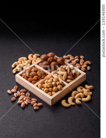 Wooden box with macadamia nuts, almonds, pistachios, and hazelnuts. Nuts as a food background Wooden box with macadamia nuts, almonds, pistachios, and hazelnuts. Nuts as a food background 139146900