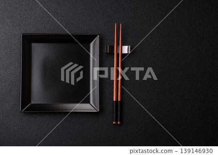 An empty ceramic square black plate with chopsticks for Asian food. An empty square plate An empty ceramic square black plate with chopsticks for Asian food. An empty square plate 139146930