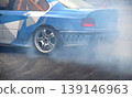Drifting car in smoke from burning tires on the track in motion 139146963