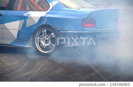 Drifting car in smoke from burning tires on the track in motion 139146963
