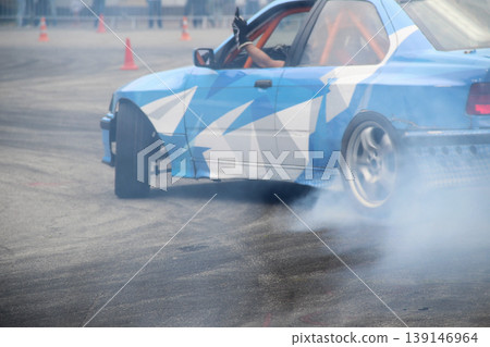 Rear wheel drive car drifting on the asphalt track with safety cones 139146964