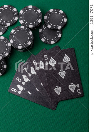 Playing cards and chips on a green cloth, a gambling game of poker. Cards and chips 139147071