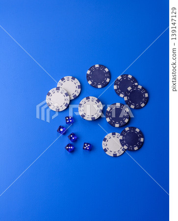 Casino dice and chips on a colored background, poker, gambling with bets. Dice and chips Casino dice and chips on a colored background, poker, gambling with bets. Dice and chips 139147129
