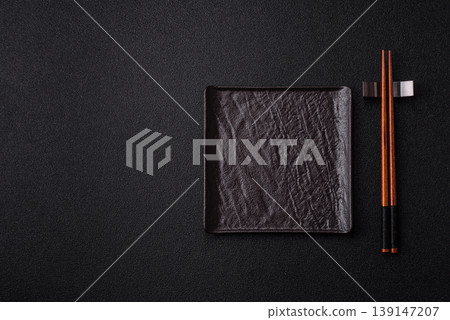 An empty ceramic square black plate with chopsticks for Asian food. An empty square plate 139147207