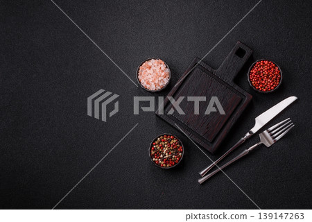 An empty wooden cutting board with cutlery on a kitchen counter. A wooden cutting board 139147263