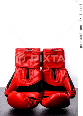 Two red boxing gloves for a fight, or as a symbol of overcoming illness. Red boxing gloves Two red boxing gloves for a fight, or as a symbol of overcoming illness. Red boxing gloves 139147421