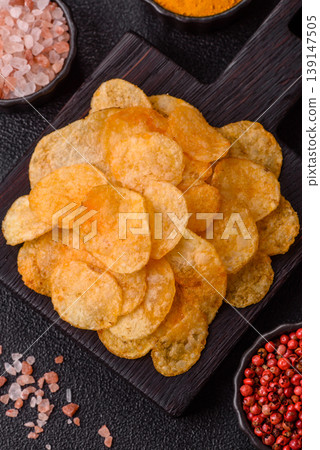 Crispy potato chips, golden slices seasoned with salt and spices. Potato chips Crispy potato chips, golden slices seasoned with salt and spices. Potato chips 139147505